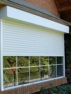 Cortina de enrollar con cajón sobre fachada de ladrillo