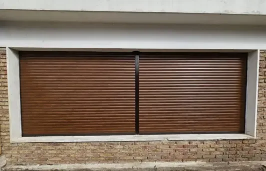 Persianas de enrollar con terminación símil madera en una casa de ladrillo