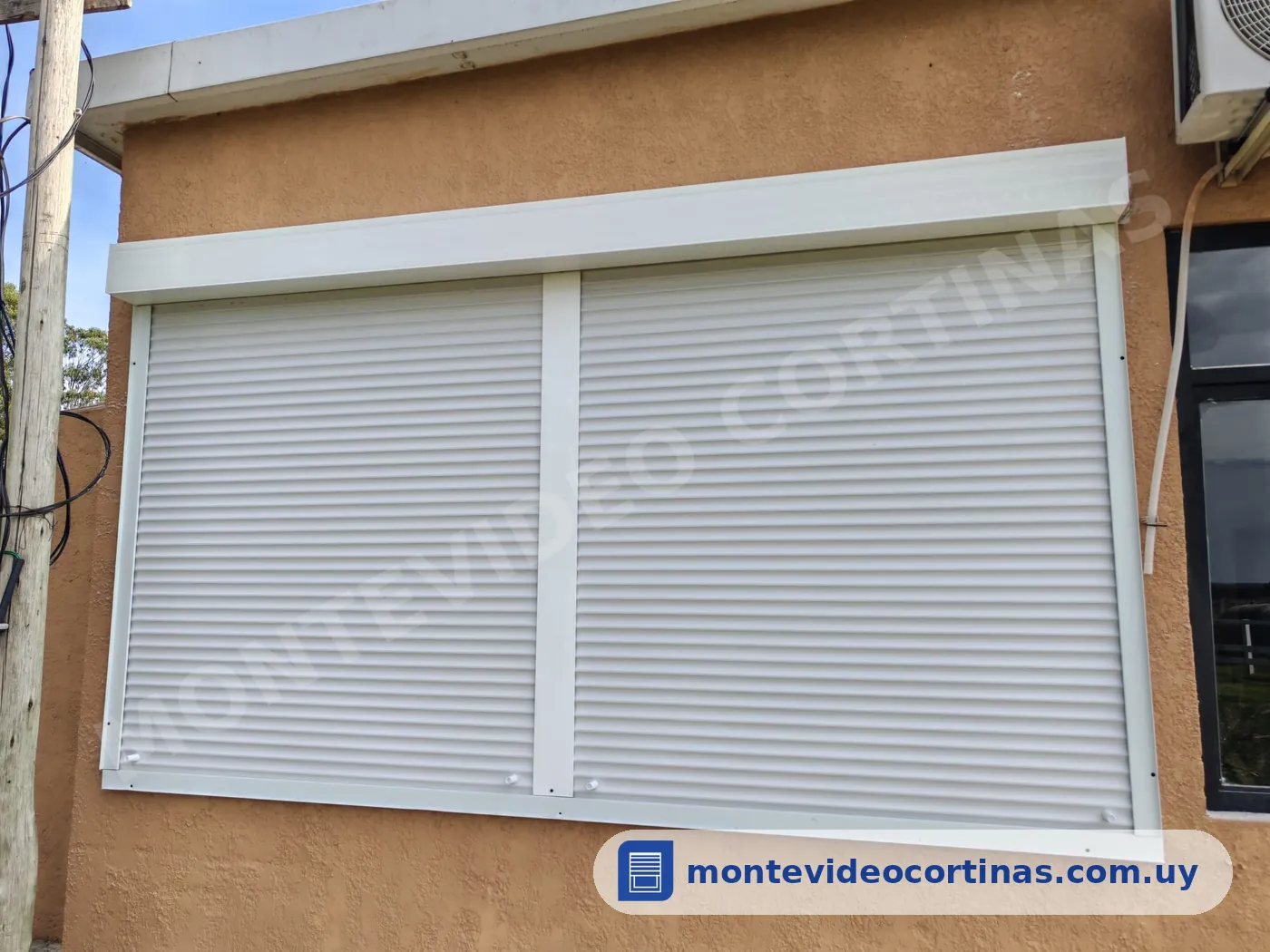 Cortinas de enrollar blancas instaladas sin albañilería en una pared exterior